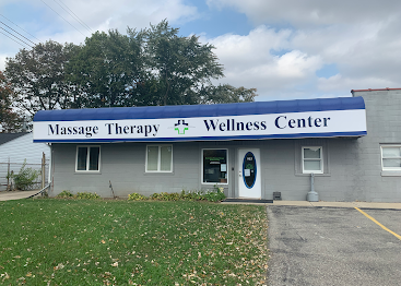 A massage therapy and wellness center building with a blue awning