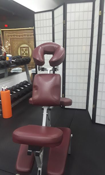 A red massage chair is sitting in a massage clinic.