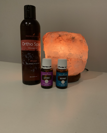Two bottles of essential oils are sitting on a table next to a lamp.