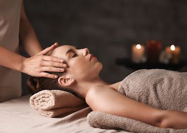 A woman is getting a head massage at a spa.