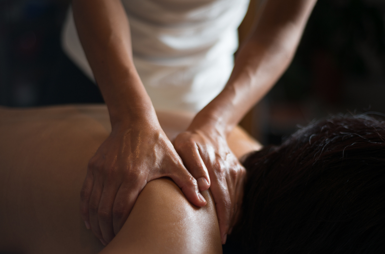 A person is getting a massage on their back in a spa.