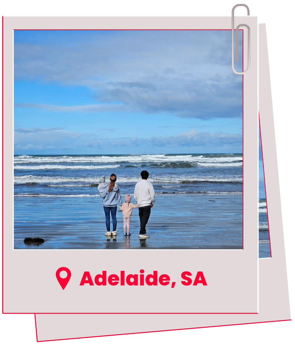 Family at beach in Adelaide, Australia. Cloudy sky, waves, person holding small child's hand.