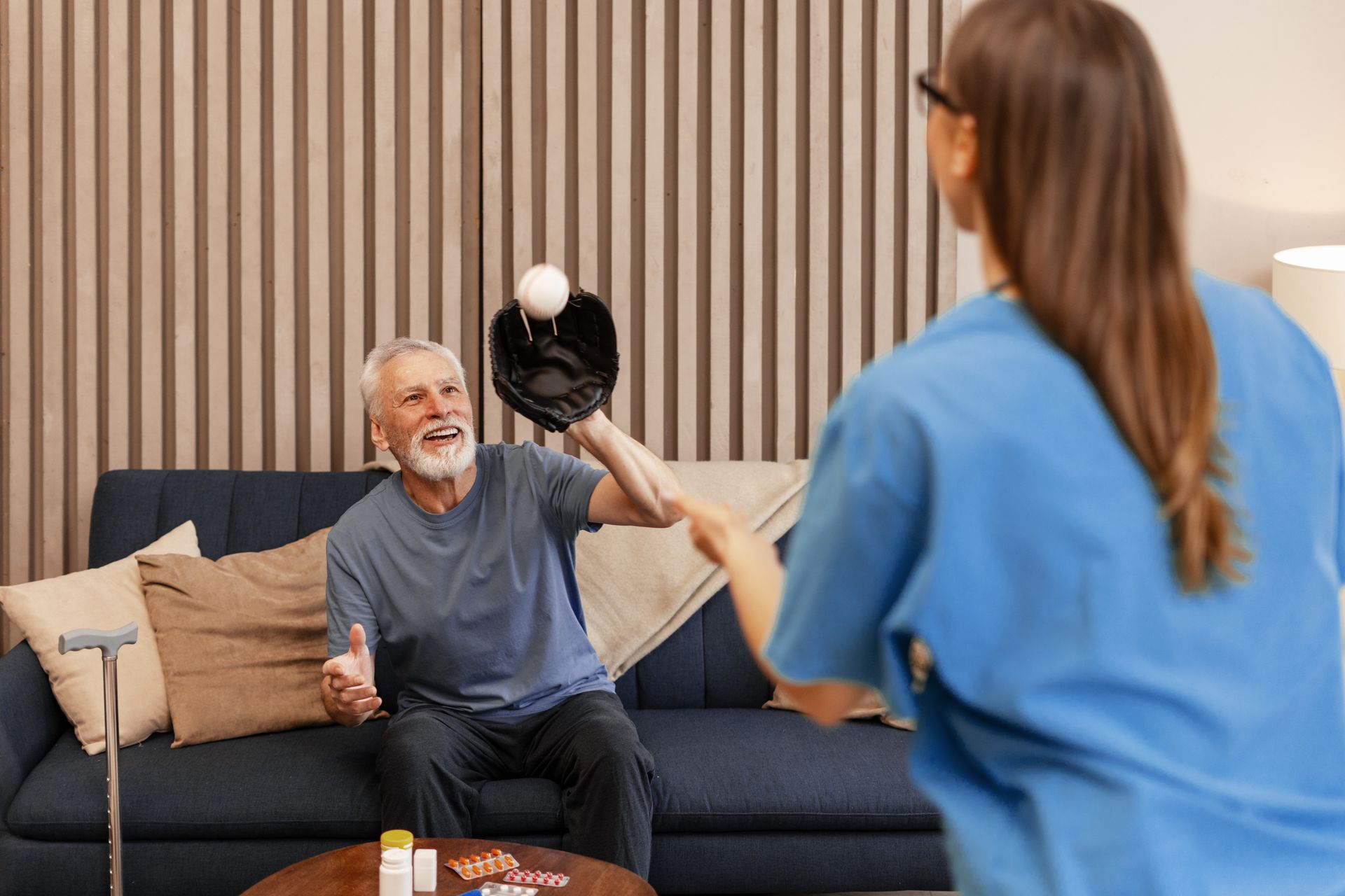 Two women conversing in a bright office; one holds a file, both smiling.