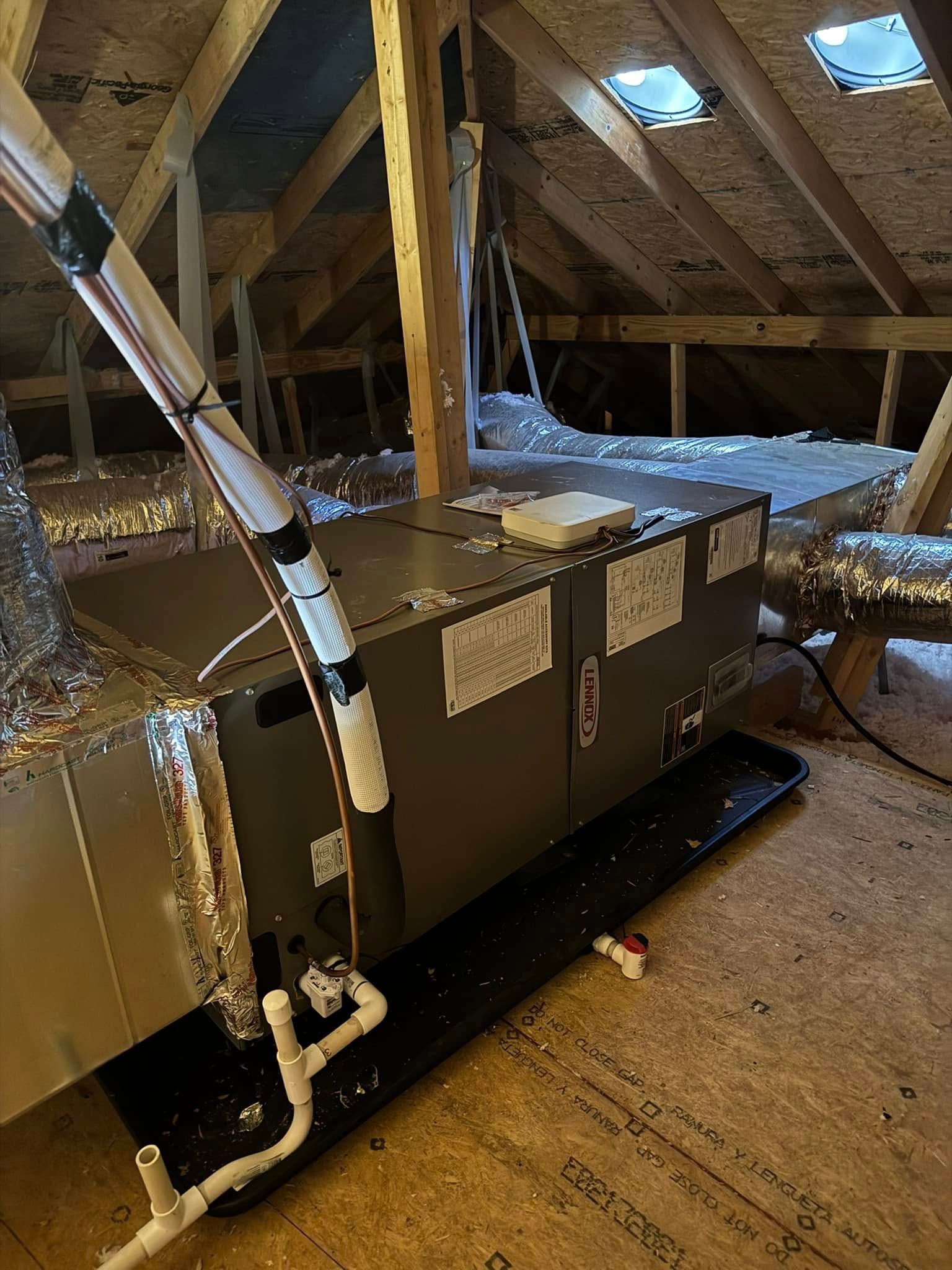 An air conditioner is sitting in the attic of a house.