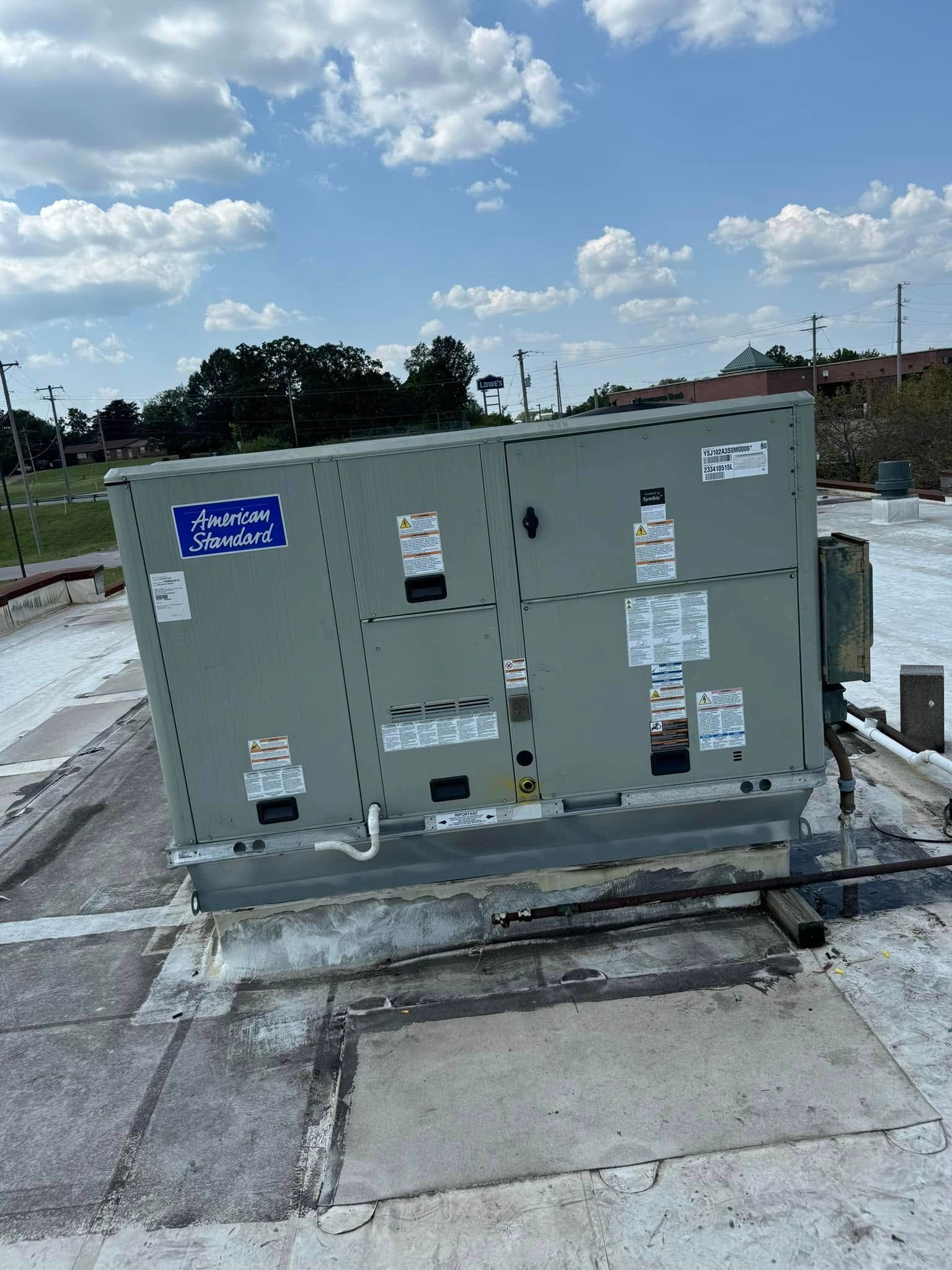A samsung air conditioner is sitting outside of a house.