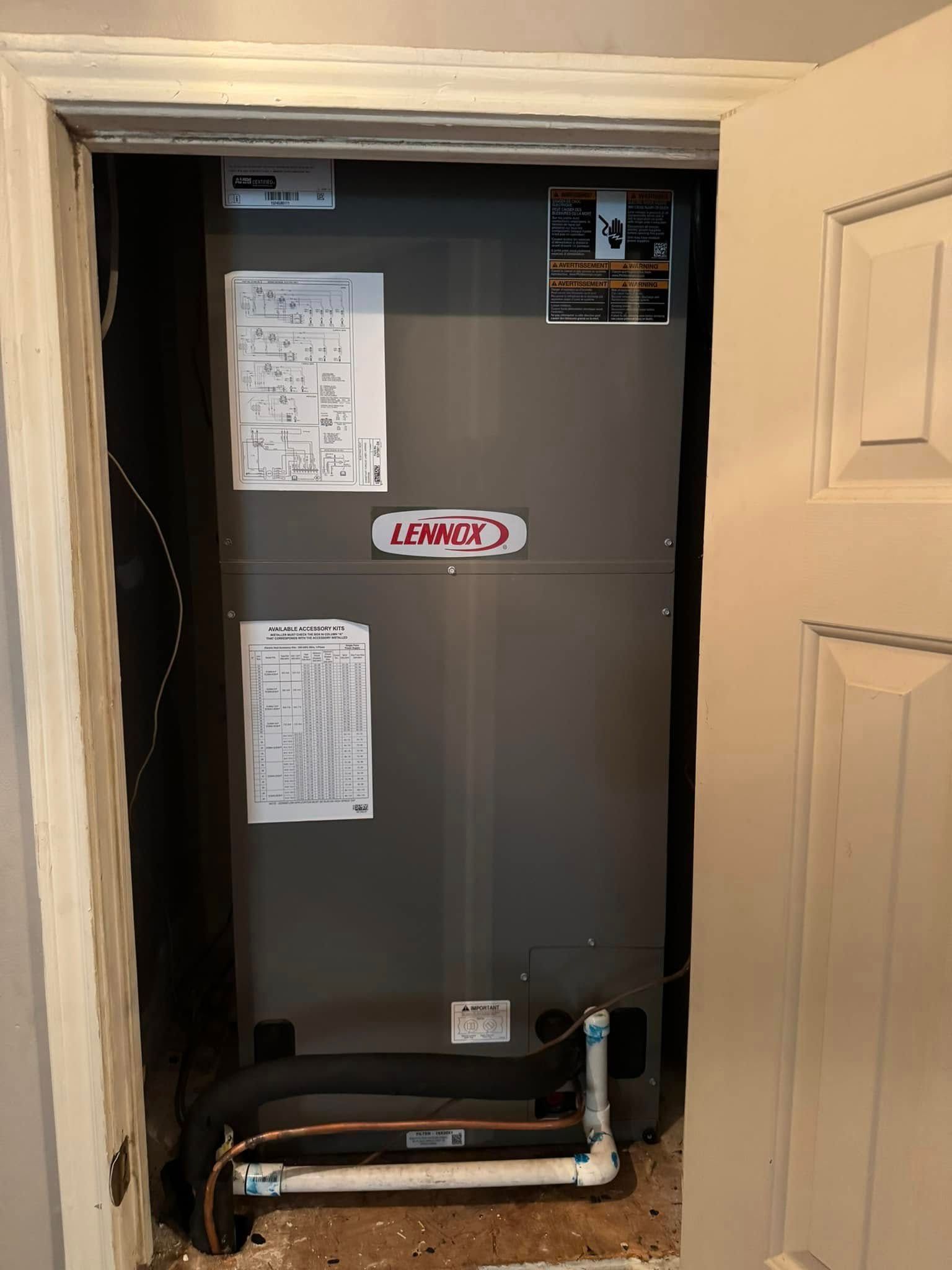 A lennox air conditioner is sitting inside of a doorway.