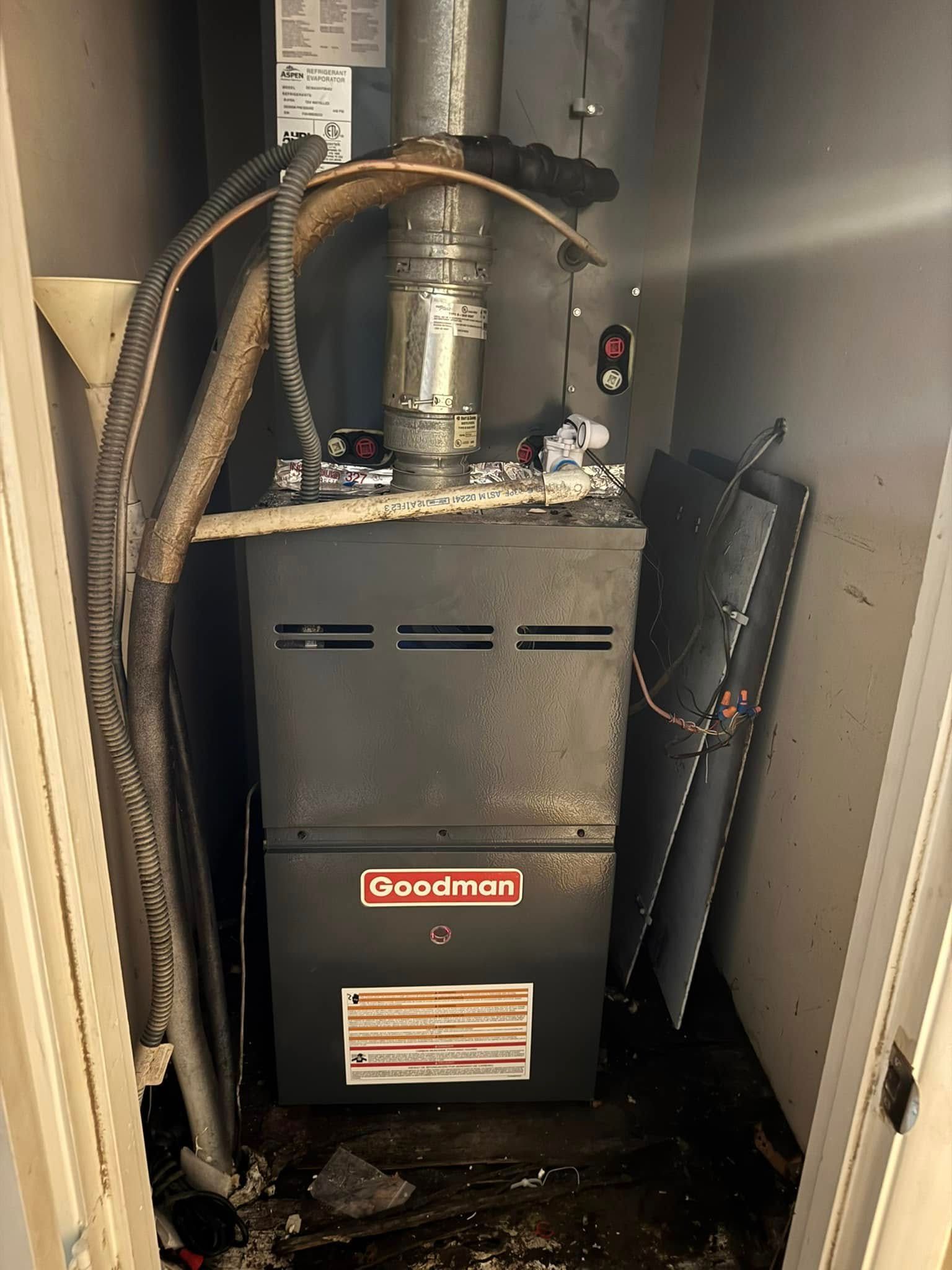 A goodman air conditioner is sitting in a dirty room.