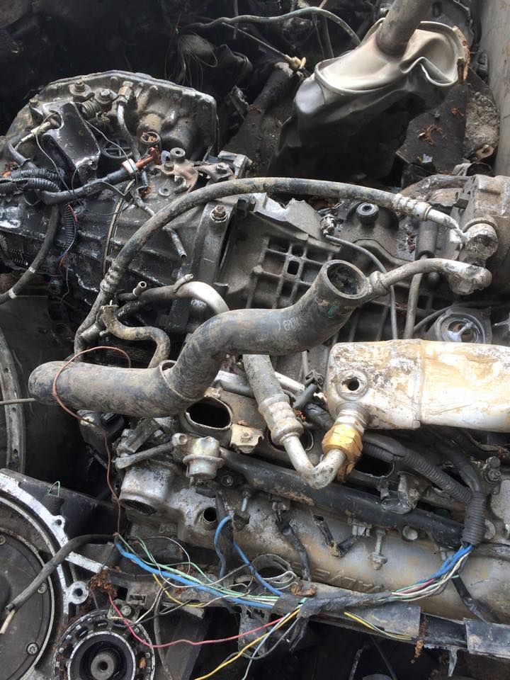 A close up of a car engine with a lot of wires coming out of it.
