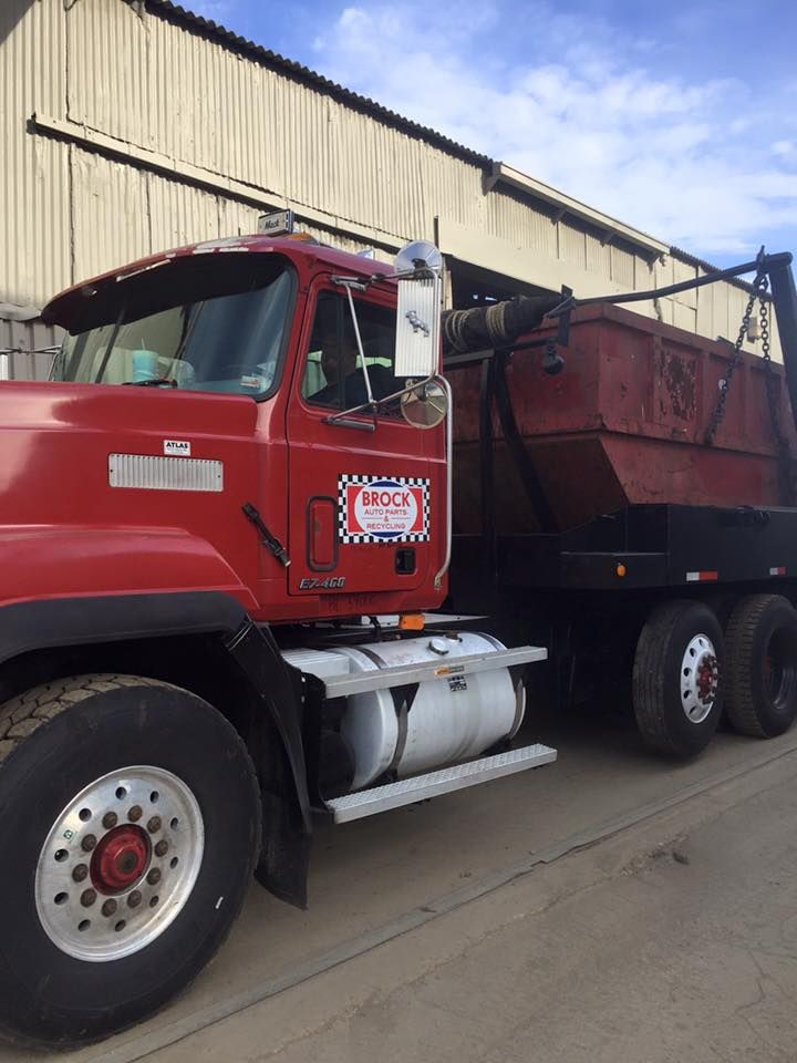 A red dump truck is parked in front of a building