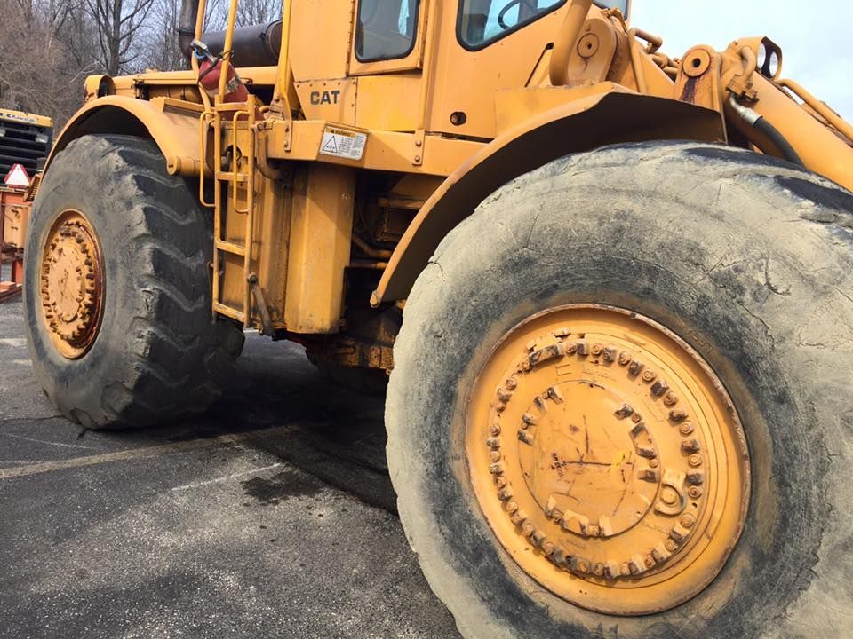 A large yellow cat tractor is parked in a parking lot