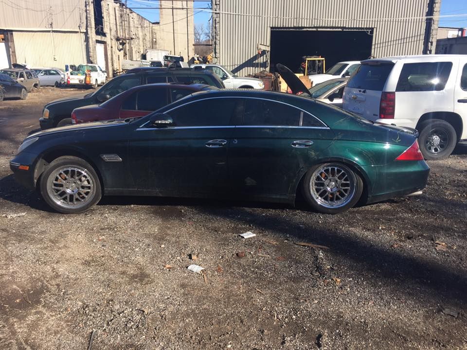 A green mercedes benz cls is parked in a parking lot.