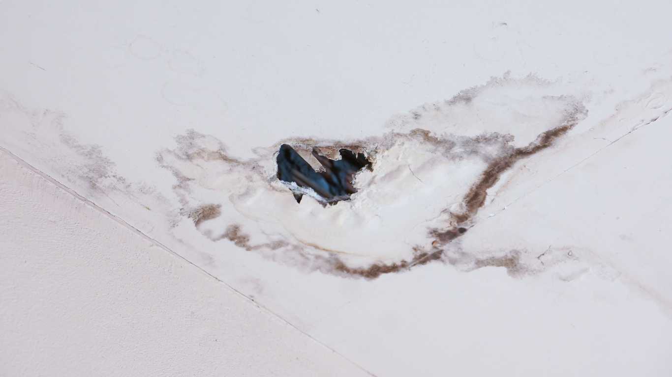 A close up of a ceiling with a hole in it.