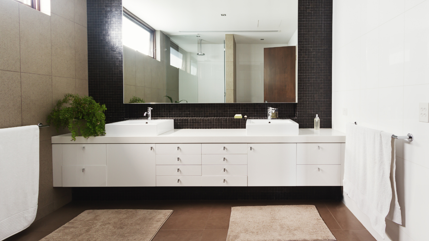 A bathroom with two sinks and a large mirror