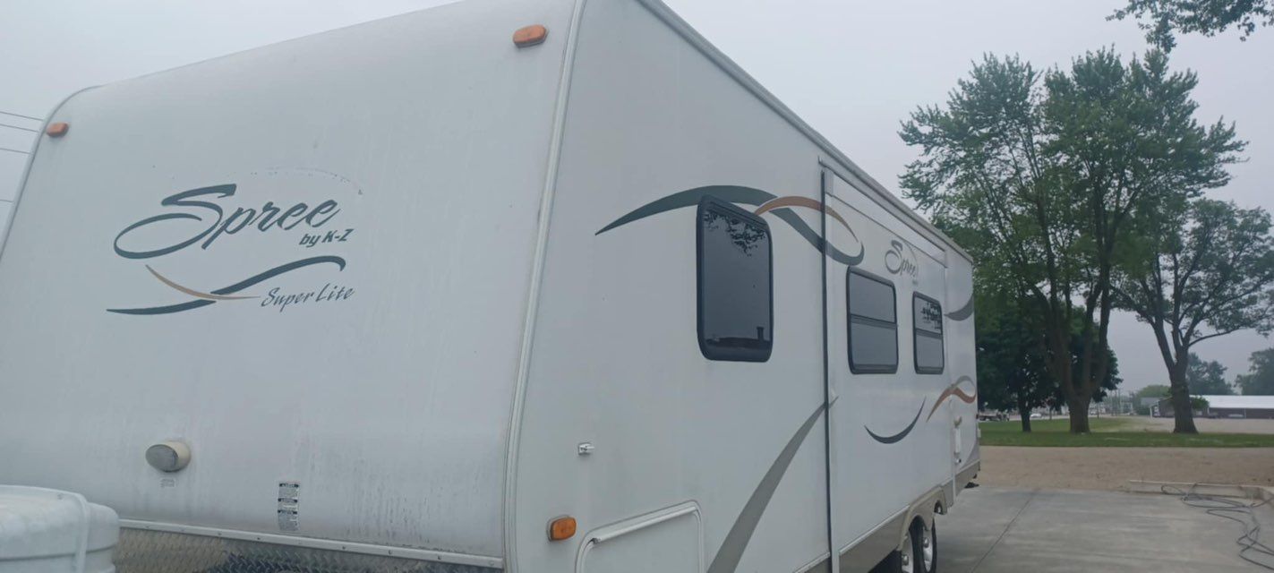 A white rv is parked on the side of the road.