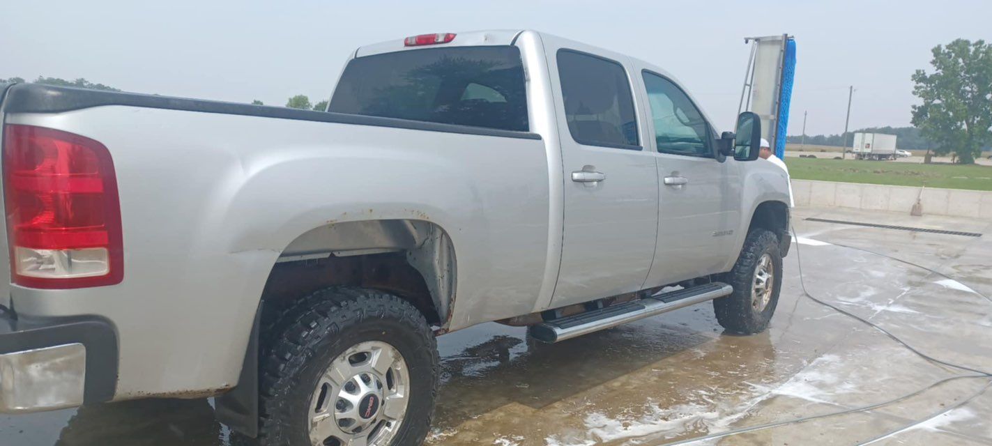 A silver pickup truck is parked in a parking lot.