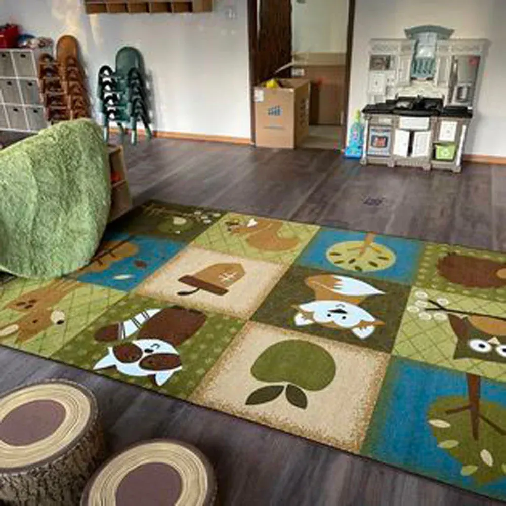 A child's playroom featuring a forest-themed area rug with animals, a play kitchen, and wooden stools on a dark floor.