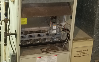 Heating Maintenance — Technician Repairing the Heater in Creve Coeur, IL