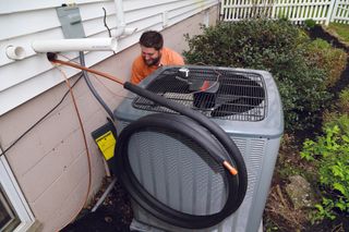 Air Conditioning Maintenance — Technician Installing New Air Conditioner in Creve Coeur, IL