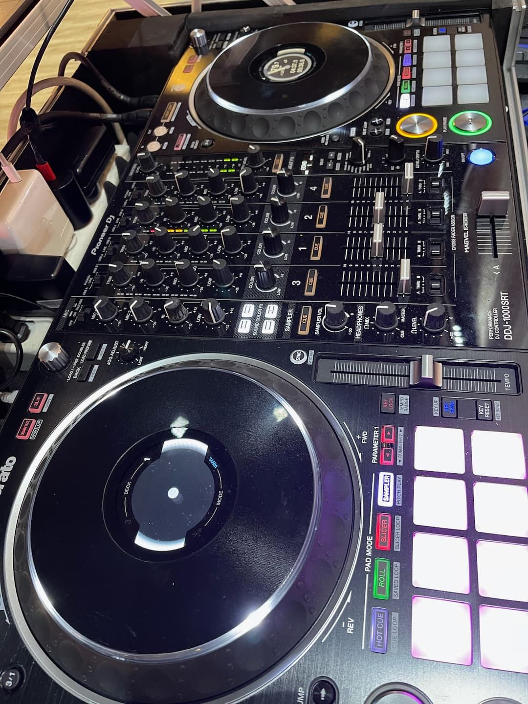 A dj mixer is sitting on a table next to a keyboard