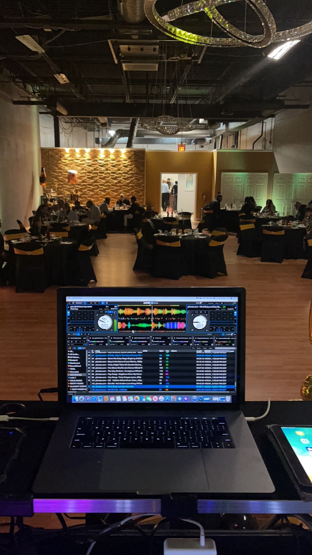 A laptop is sitting on a table in front of a large room.