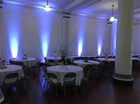 A large room with tables and chairs and purple lights on the walls.