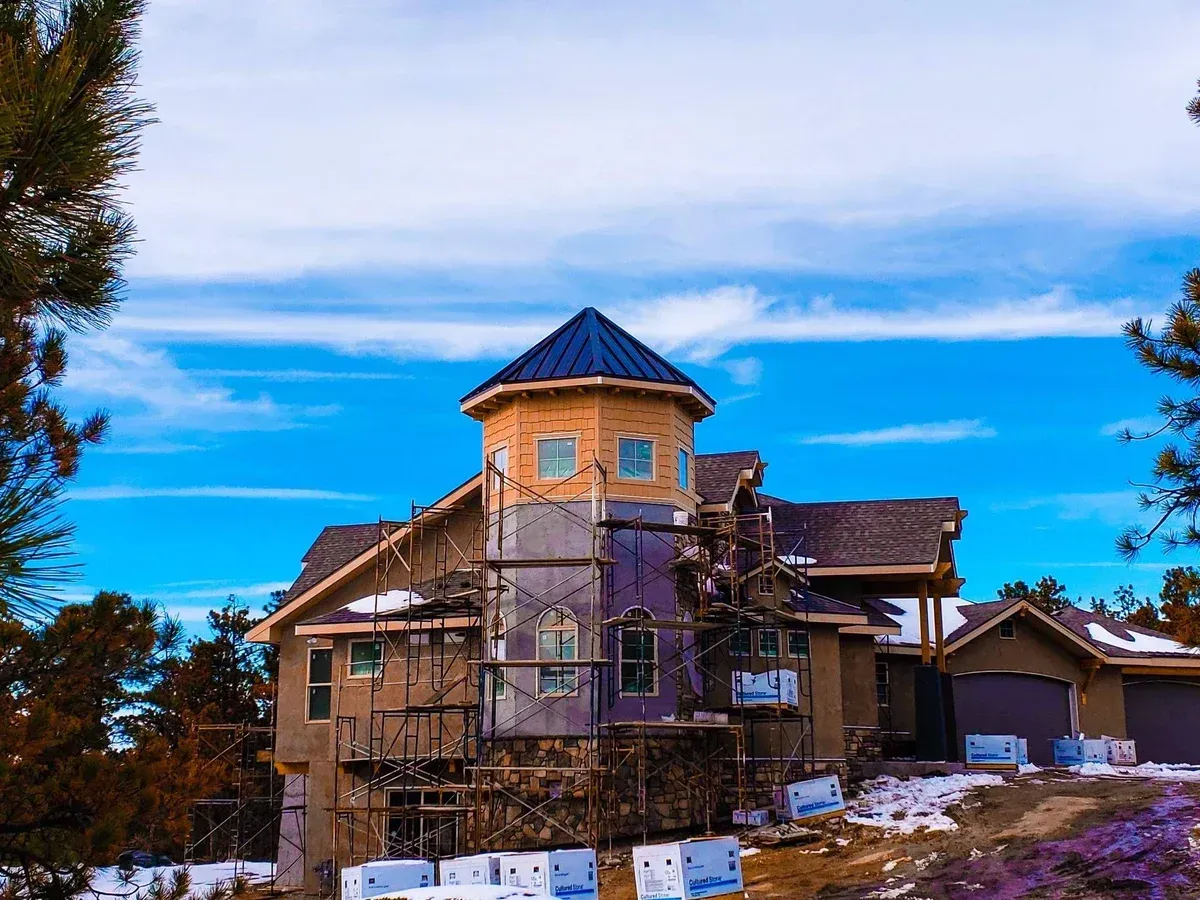 A large house under construction with a blue sky in the background