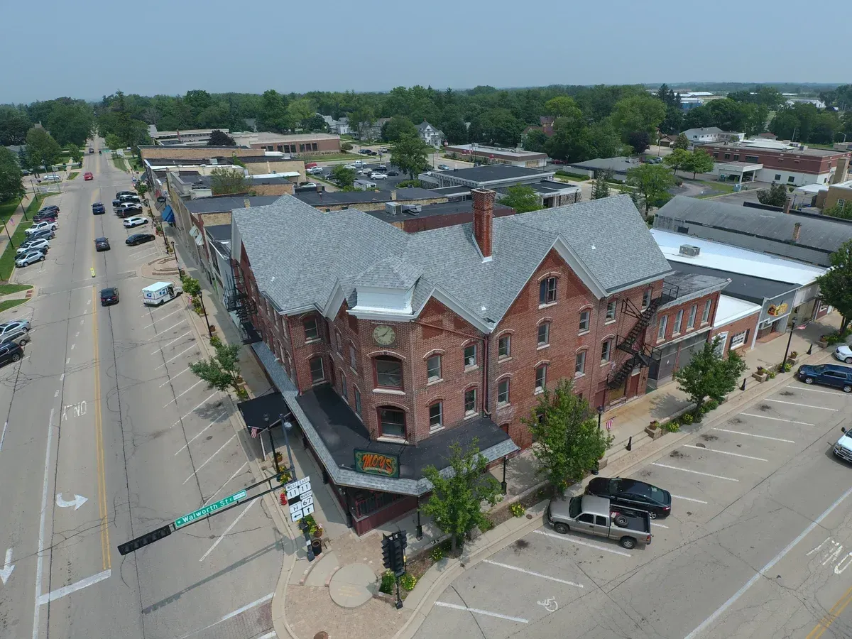 An aerial view of a large brick building in a small town.