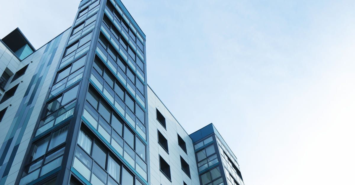 A tall building with a lot of windows against a blue sky.