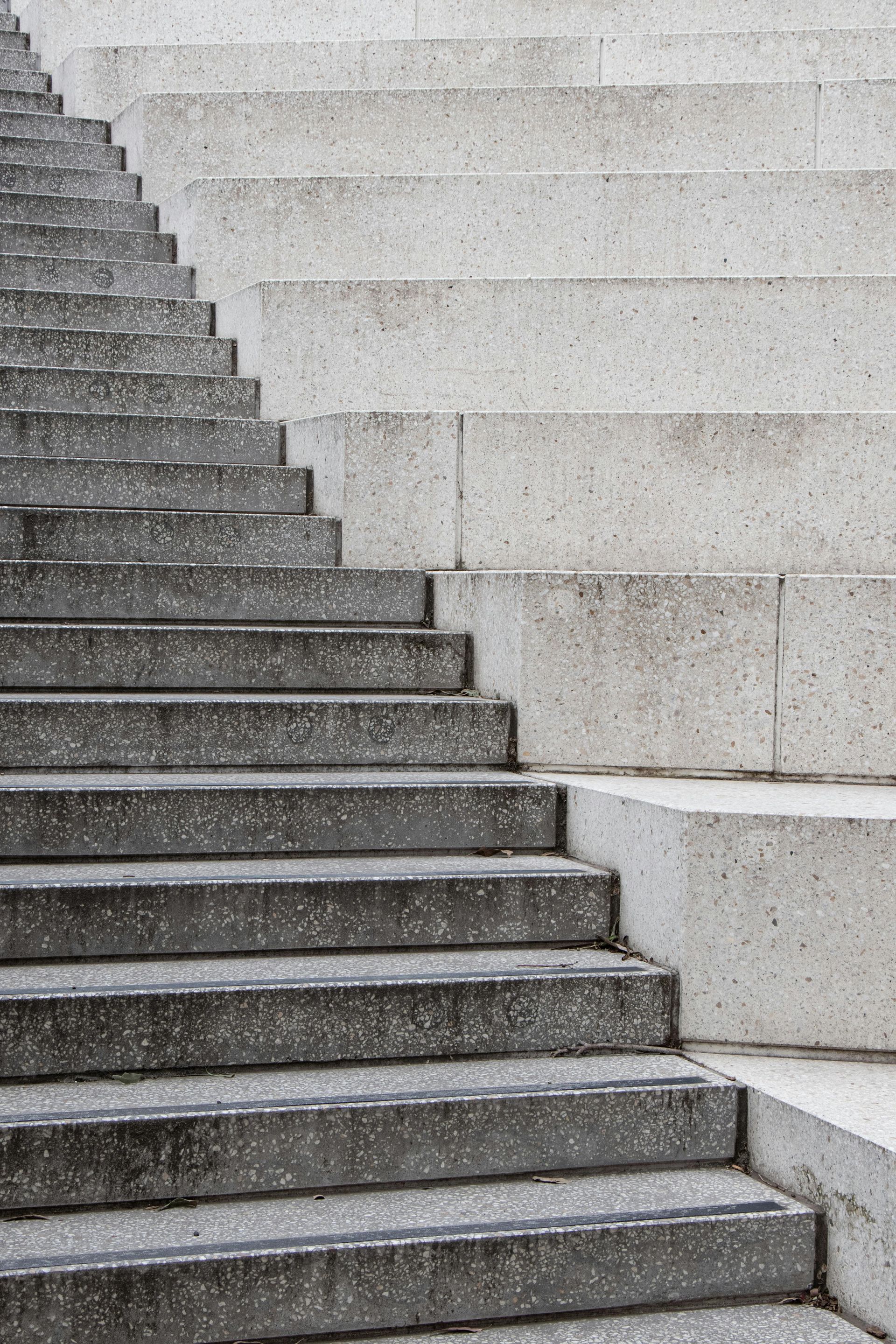 Concrete staircase ascending diagonally, with weathered steps on the left and solid blocks on the right.
