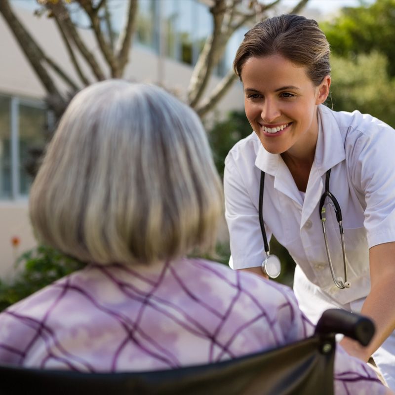 A caregiver giving assistance to an elderly woman