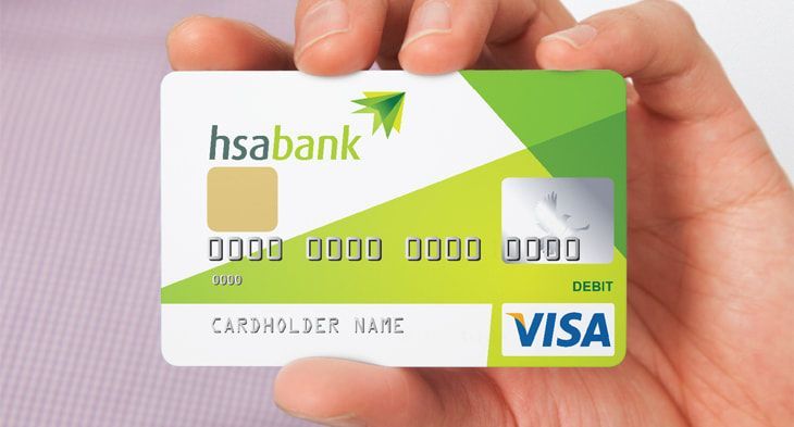 Hand holding a white and green HSA Bank debit card with VISA logo.