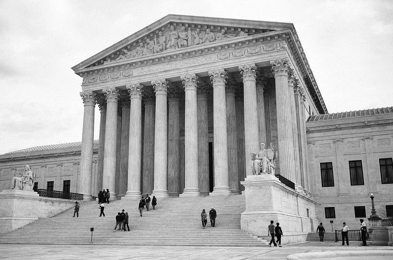 The United States Supreme Court building in Washington, D.C., with people walking up the steps.