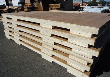 Stacked wooden pallets at an outdoor lumber yard