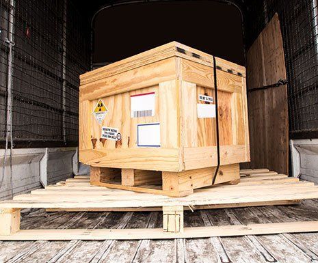 Wooden shipping crate on a pallet inside a truck trailer