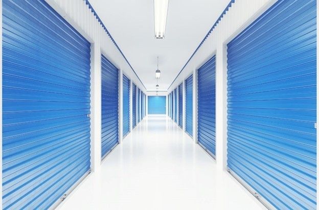 A long hallway with blue doors and white walls