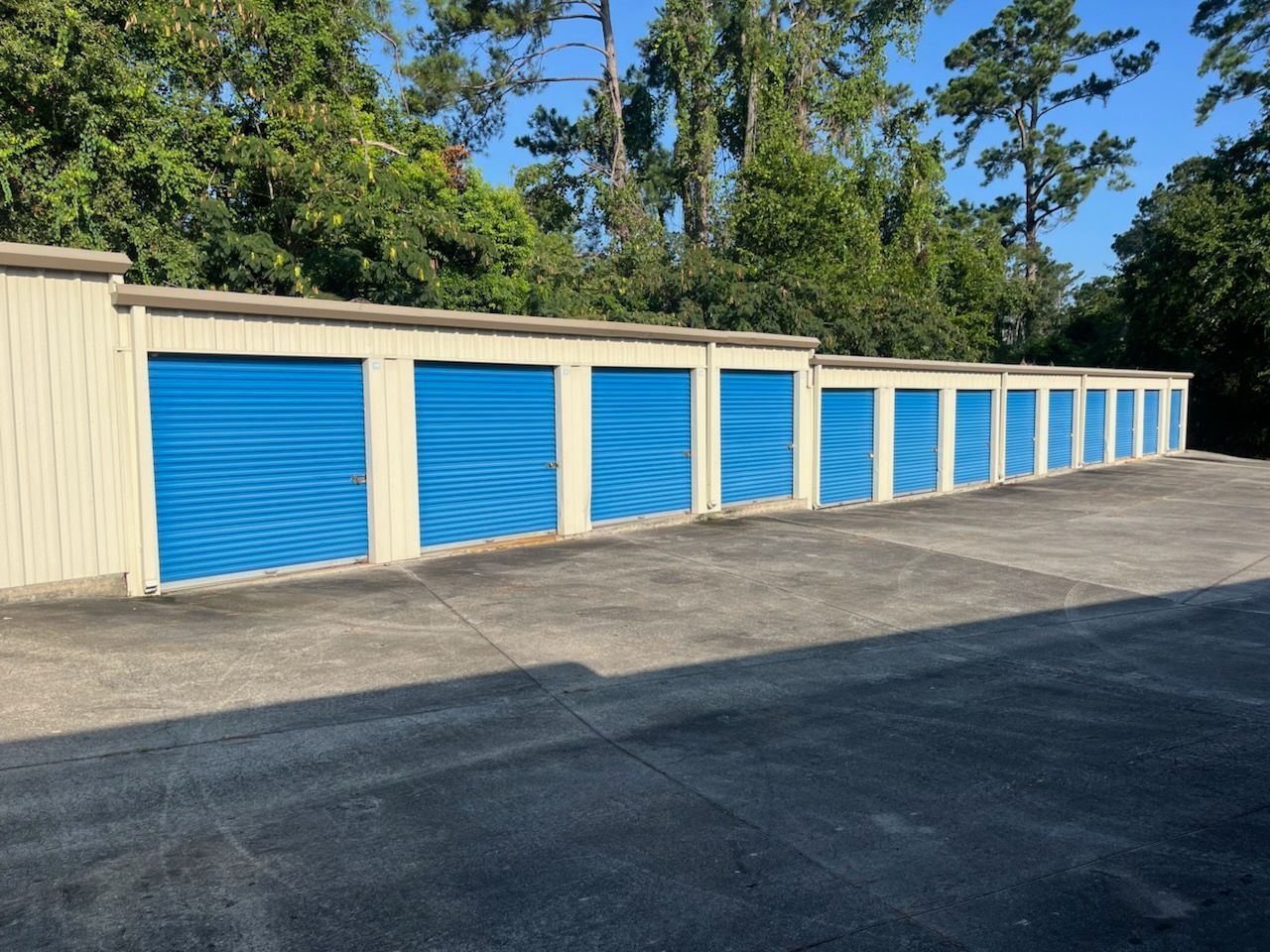 A woman is sitting at a table using a laptop and a cell phone.