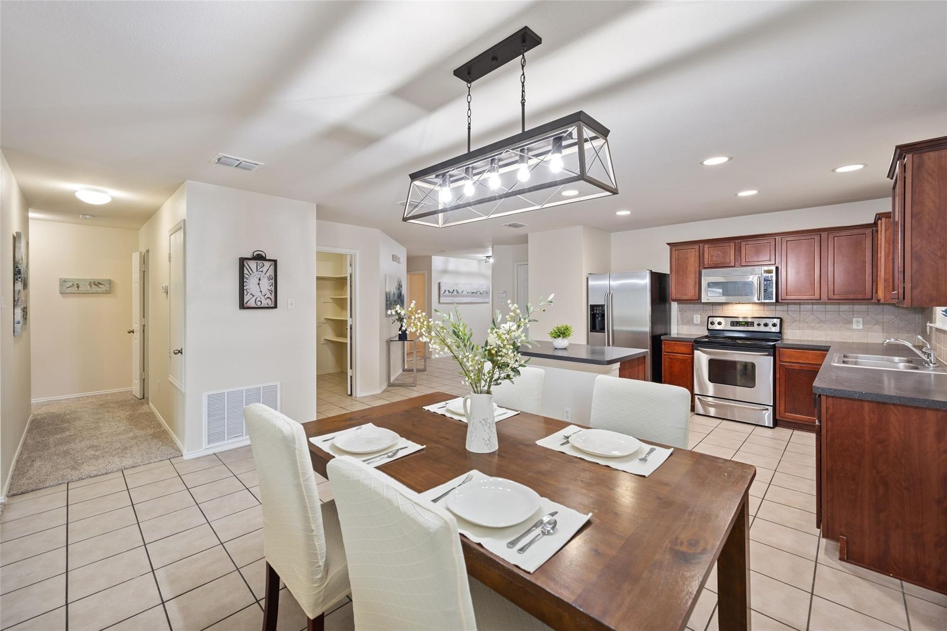 a kitchen with a table and chairs and a clock on the wall