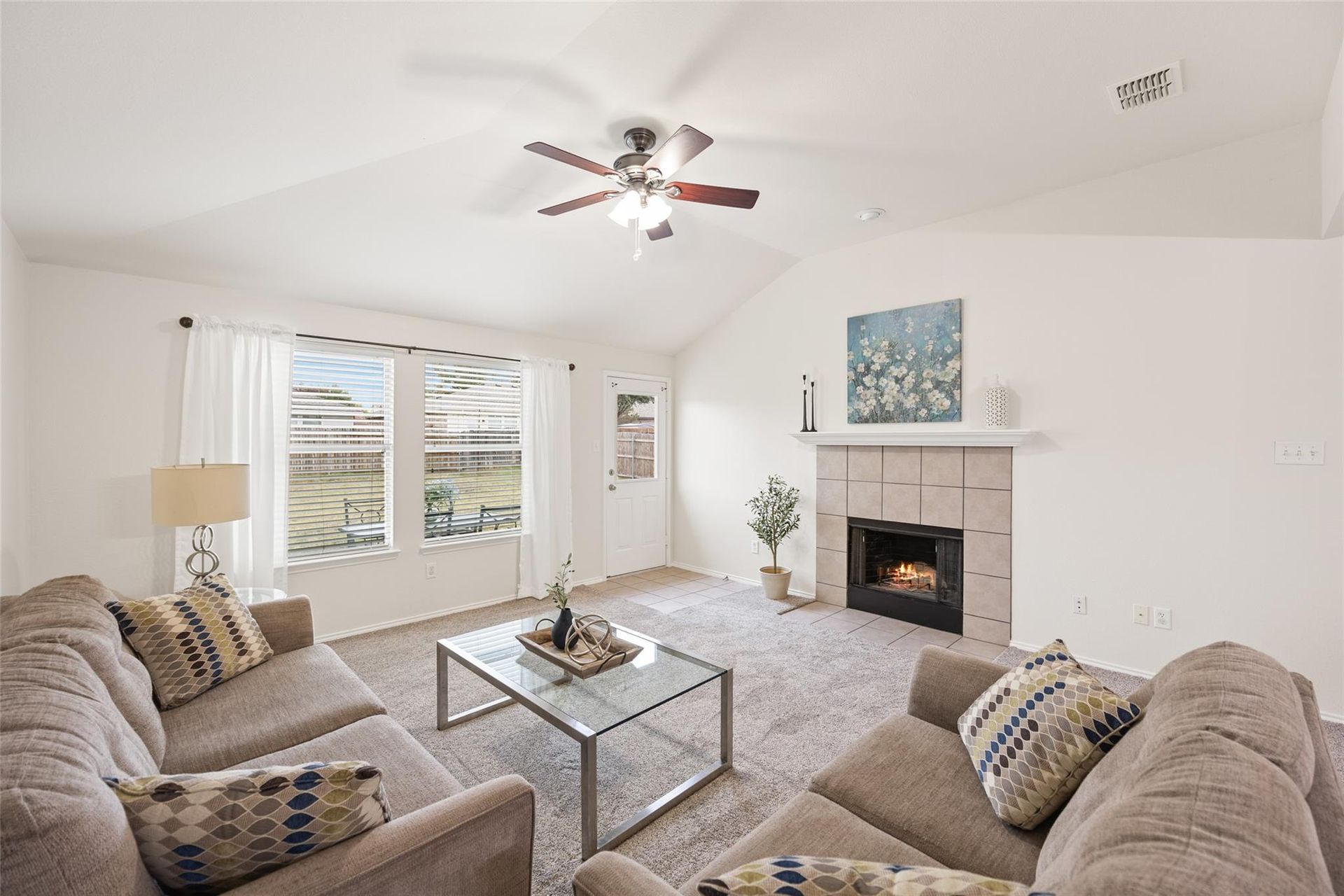 a living room with a fireplace and a ceiling fan