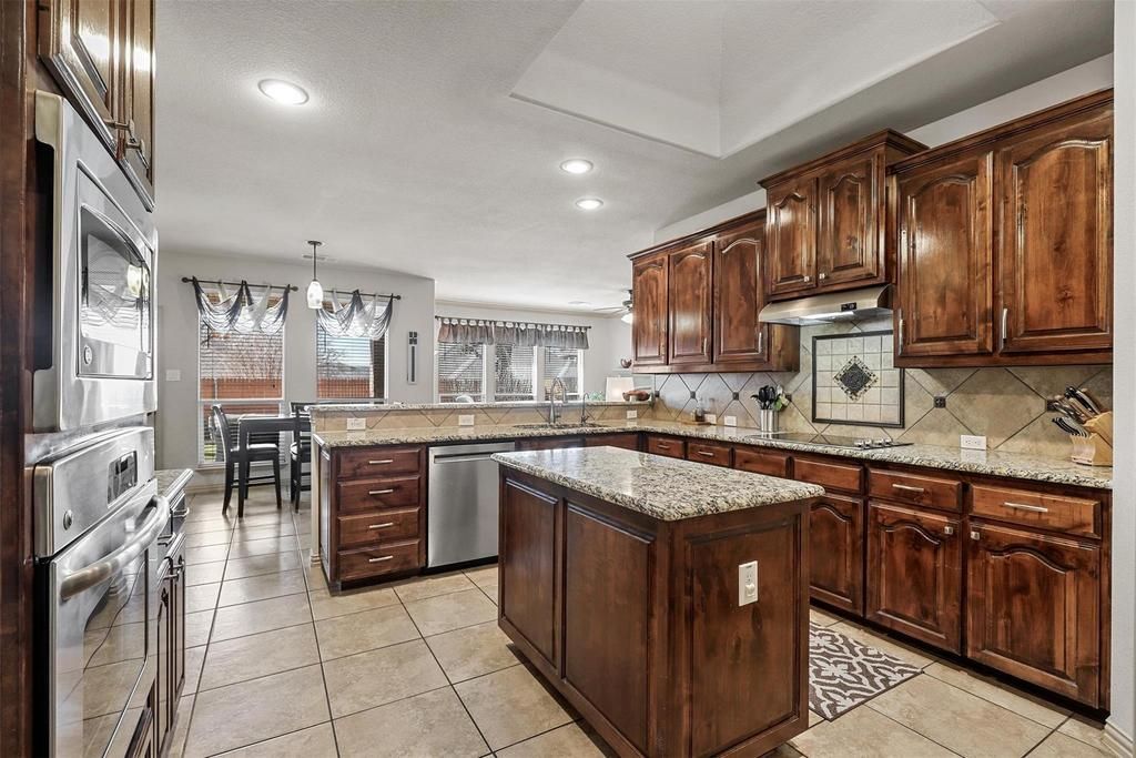 there is a dining table and chairs in the middle of the room .