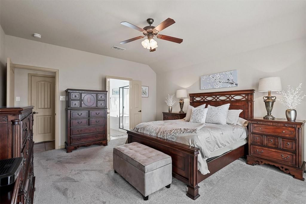 a living room with a chair , desk , chair and ceiling fan .