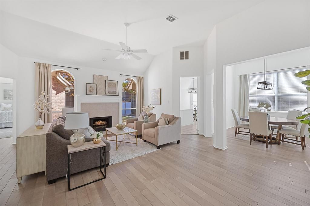a living room with a fireplace and a ceiling fan