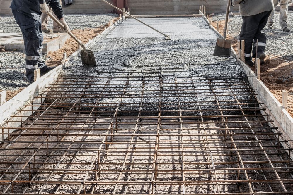 image of construction workers pouring and laying concrete