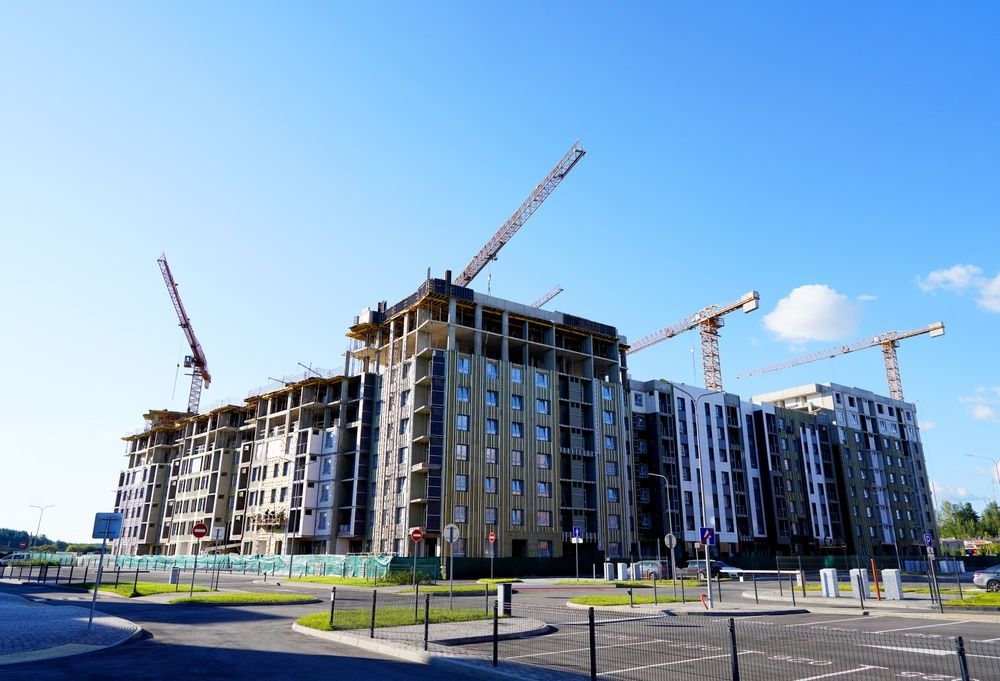 A large building is being built with cranes in the background.