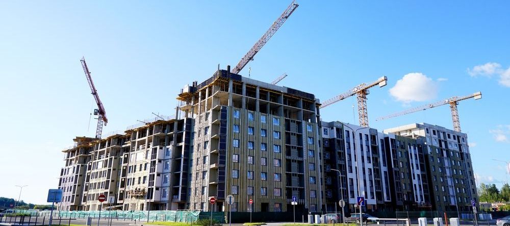 A large building is being built with cranes in the background.