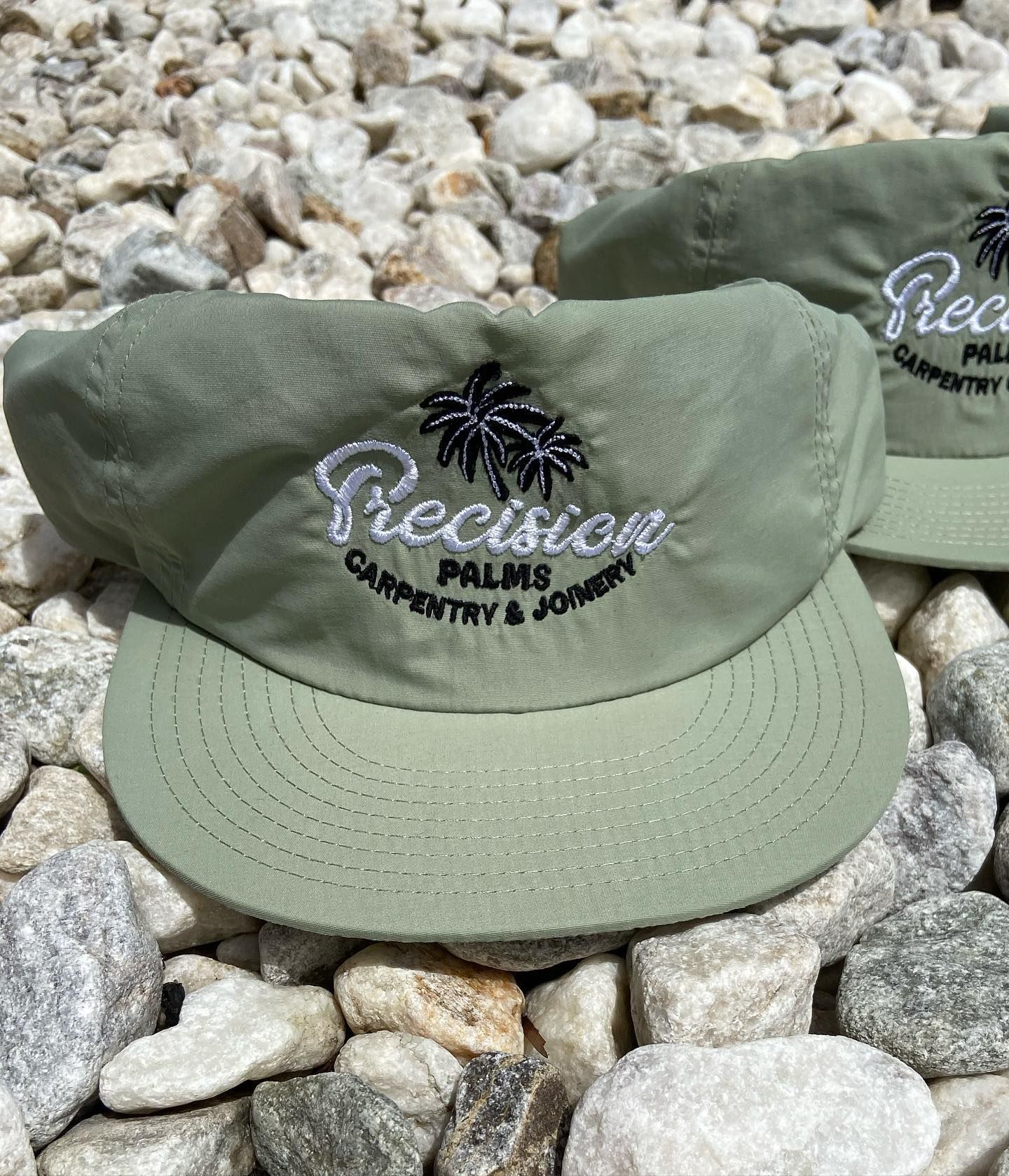 Two green hats are sitting on top of a pile of rocks.