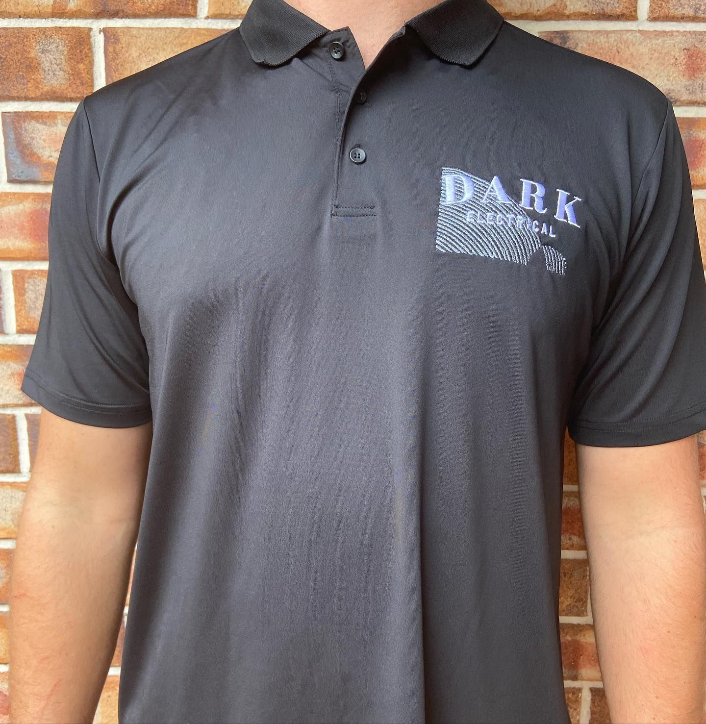 A man wearing a black dark electrical polo shirt