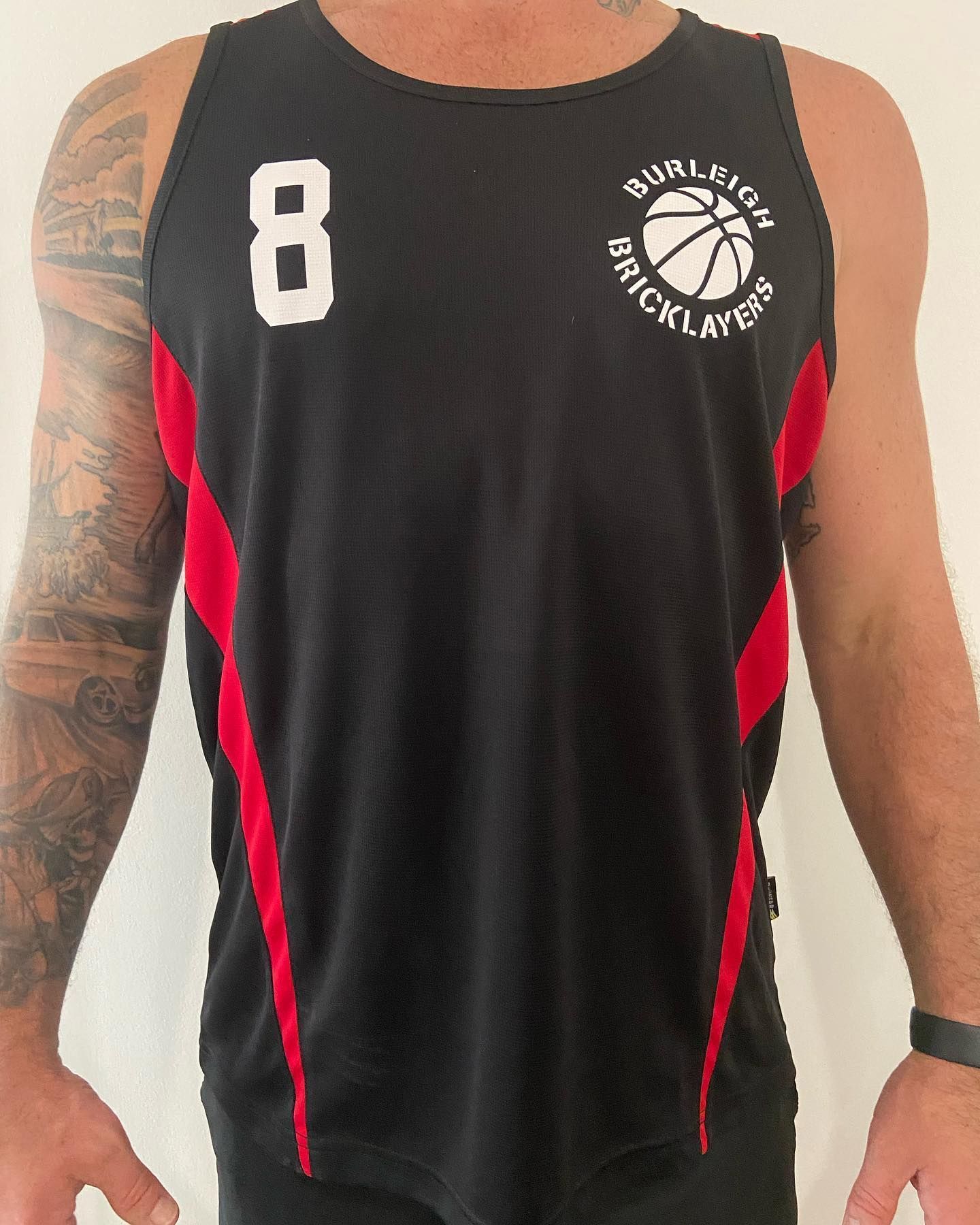 A man is wearing a black tank top with the number 8 on it