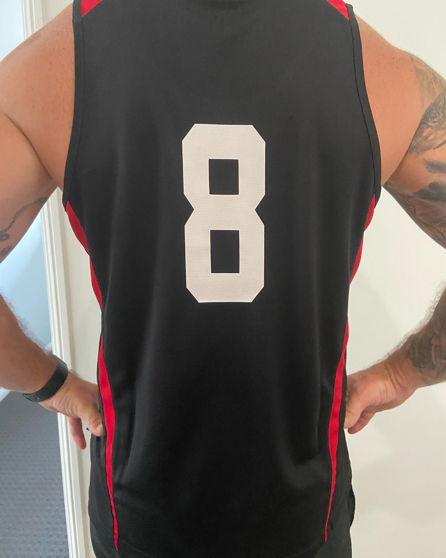 A man wearing a black jersey with the number 8 on the back