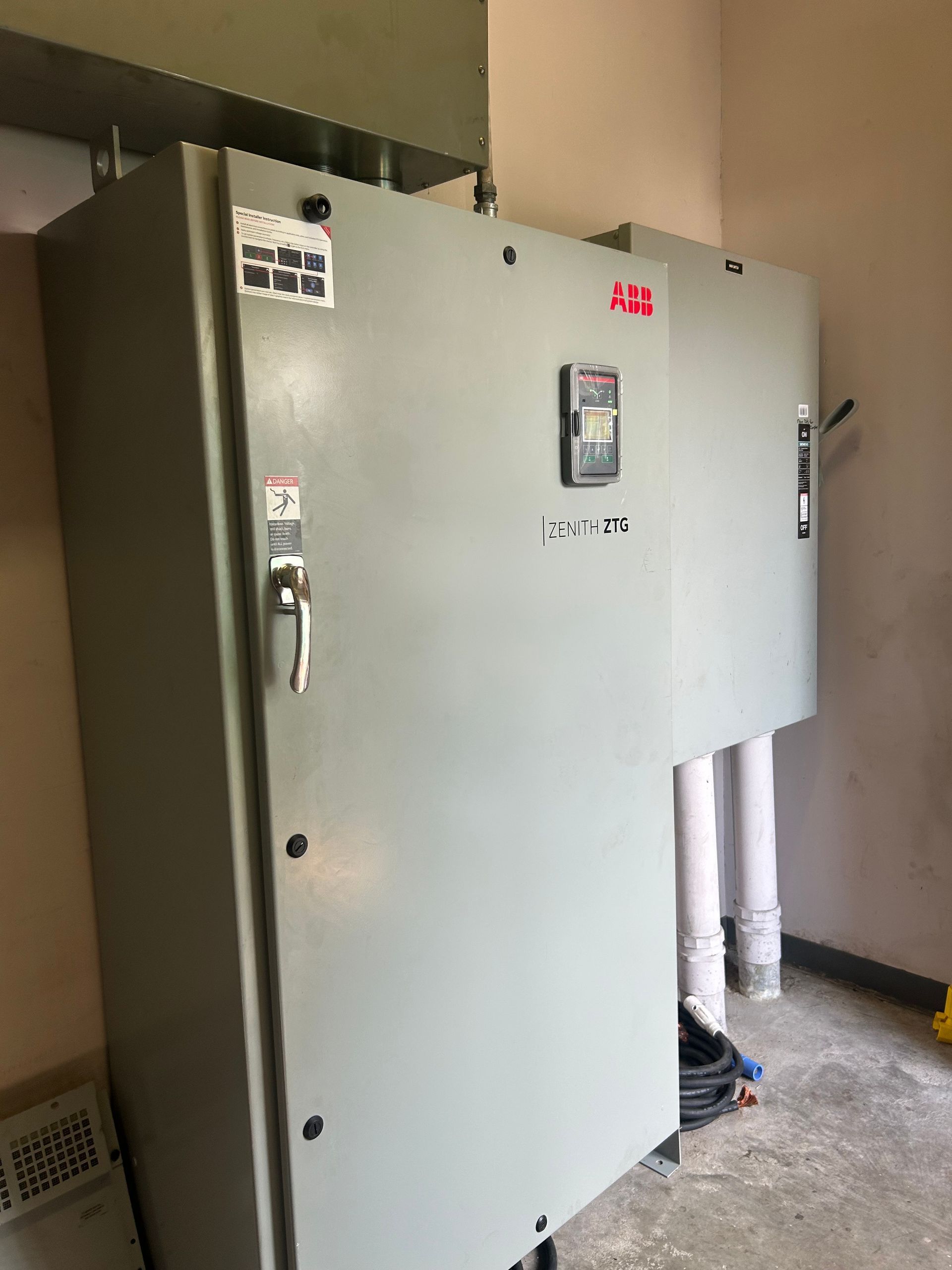 Two large gray electrical cabinets mounted on a wall, likely an industrial setting.