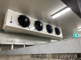 A large fan is hanging from the ceiling of a room.